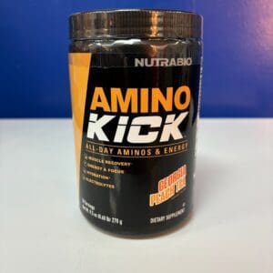 A container of amino kick is sitting on the counter.