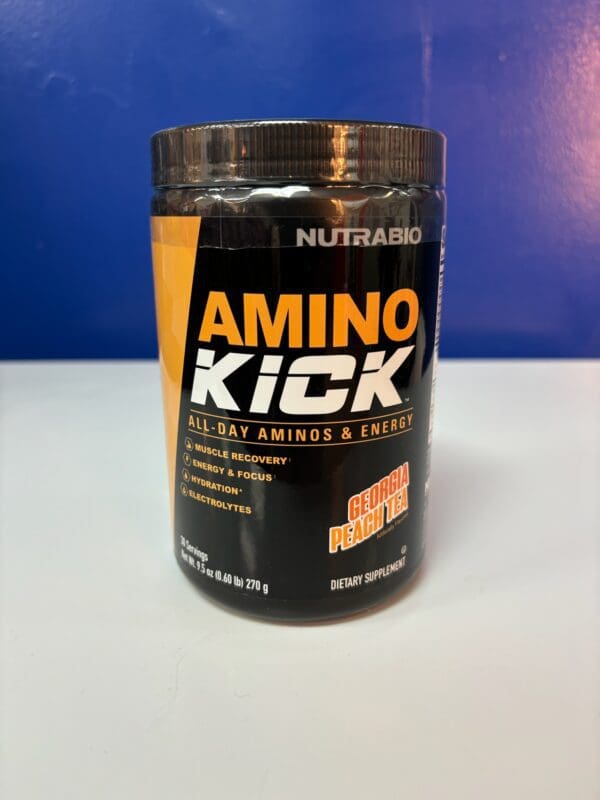 A container of amino kick is sitting on the counter.