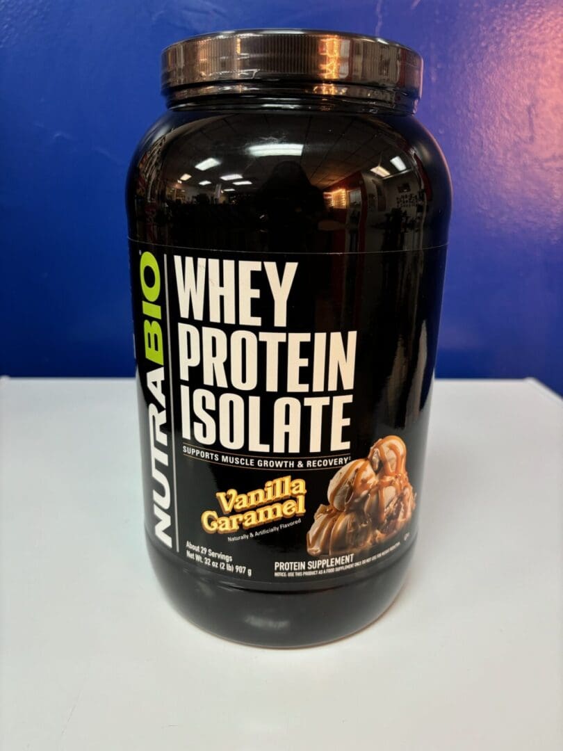 A bottle of whey protein is sitting on the counter.