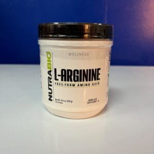 A white container of l-arginine is sitting on the counter.