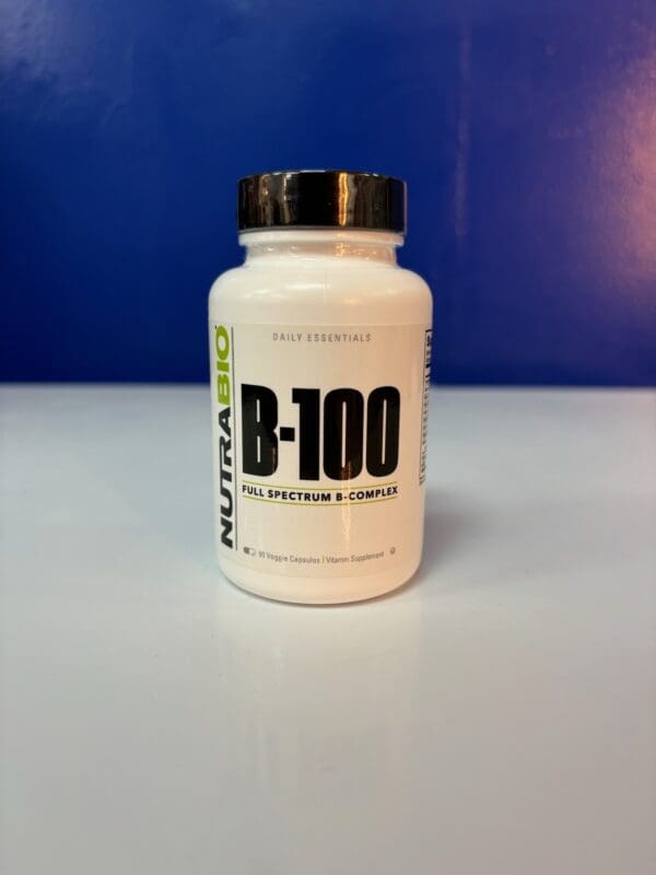 A bottle of vitamin b 1 0 0 is sitting on the table.