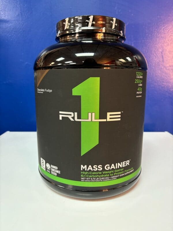 A bottle of rule 1 mass gainer on top of a table.