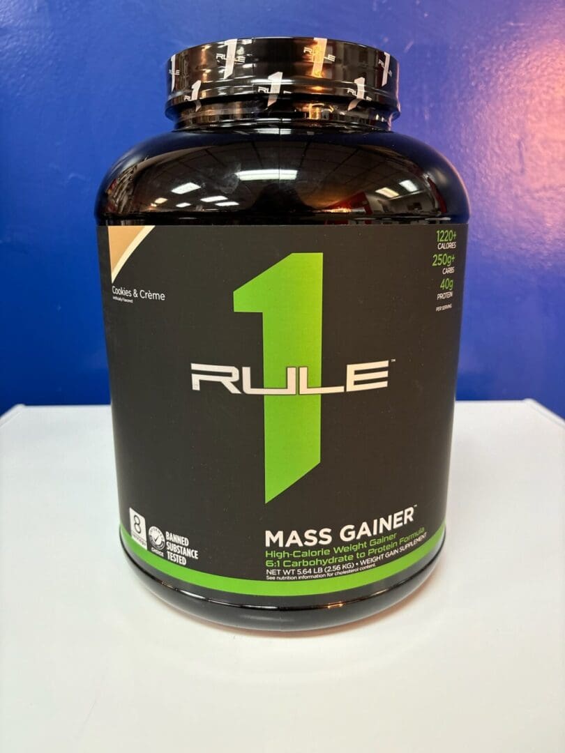 A bottle of rule 1 mass gainer on top of a table.